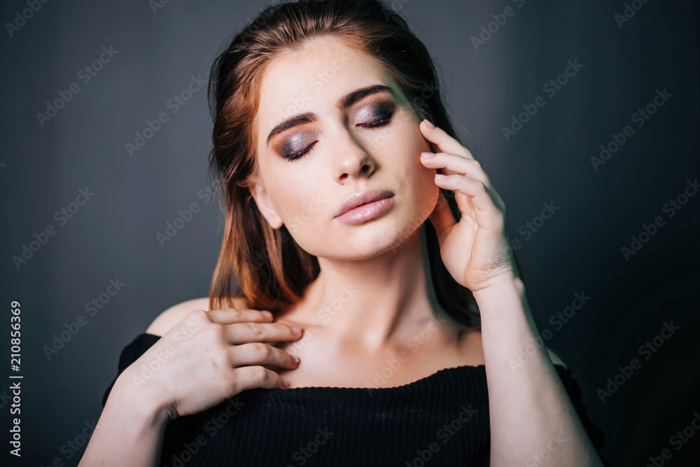 beauty portrait. Studio portrait of a beautiful girl on a gray background. Good make-up. Face close-up beauty portrait. Studio portrait of a beautiful girl on a gray background. Good make-up. Face close-up