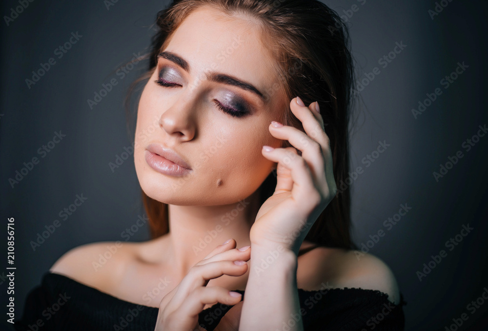 beauty portrait. Studio portrait of a beautiful girl on a gray background. Good make-up. Face close-up beauty portrait. Studio portrait of a beautiful girl on a gray background. Good make-up. Face close-up