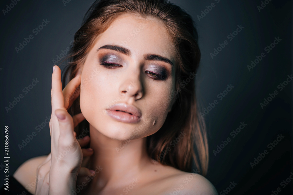 beauty portrait. Studio portrait of a beautiful girl on a gray background. Good make-up. Face close-up