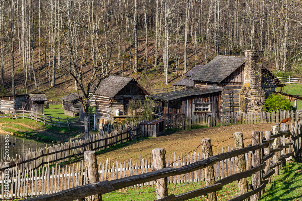 A rustic log cabin farm or homestead with a fence leading the way. Stock  Photo | Adobe Stock