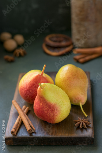 Yellow pears on a wooden board with cinnamon and anise
