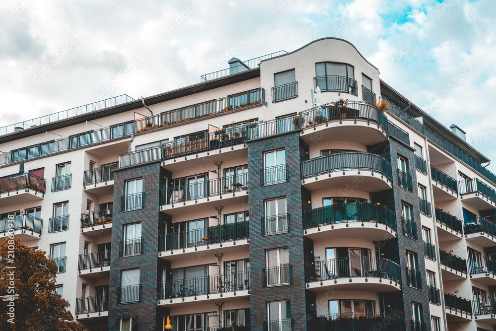 white and black colored corner building with curved balcony