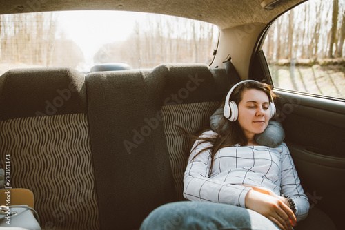 Obraz na płótnie woman sitting at car backseats and listening music. car travel c