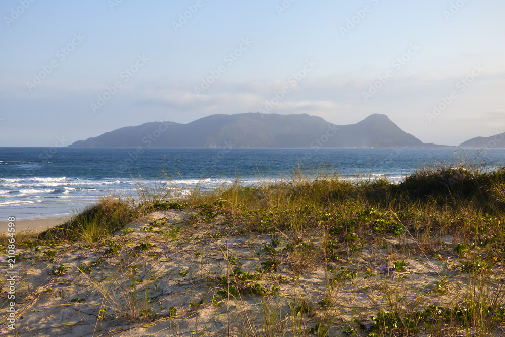A view of Campeche beach with mountains in the background - Florianopolis, Brazil