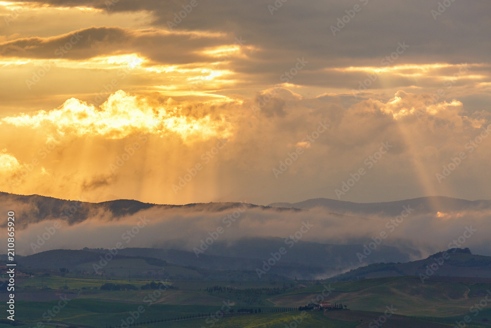 Sunset over the mountains with sun rays and low clouds Sunset over the mountains with sun rays and low clouds