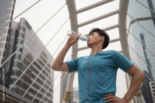 Canvas Print athlete man drink water after jogging in town