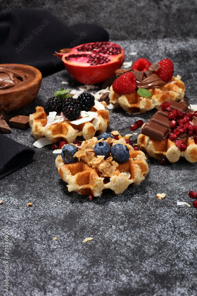 Fototapeta premium Belgian waffles with pomegranate and raspberries, homemade healthy breakfast with mint