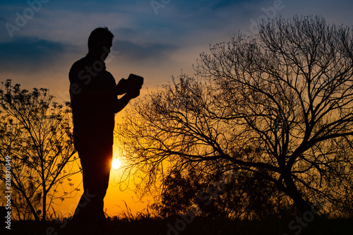 Man meditating in the field at sunrise