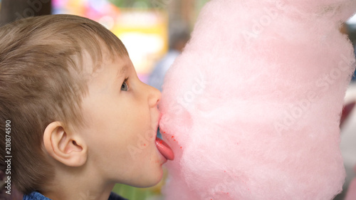 Baby eating cotton candy in the Park. Sweet and airy dessert