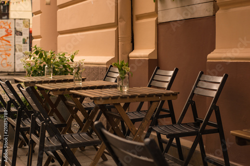 Chairs and table in the street. Cozy cafe.