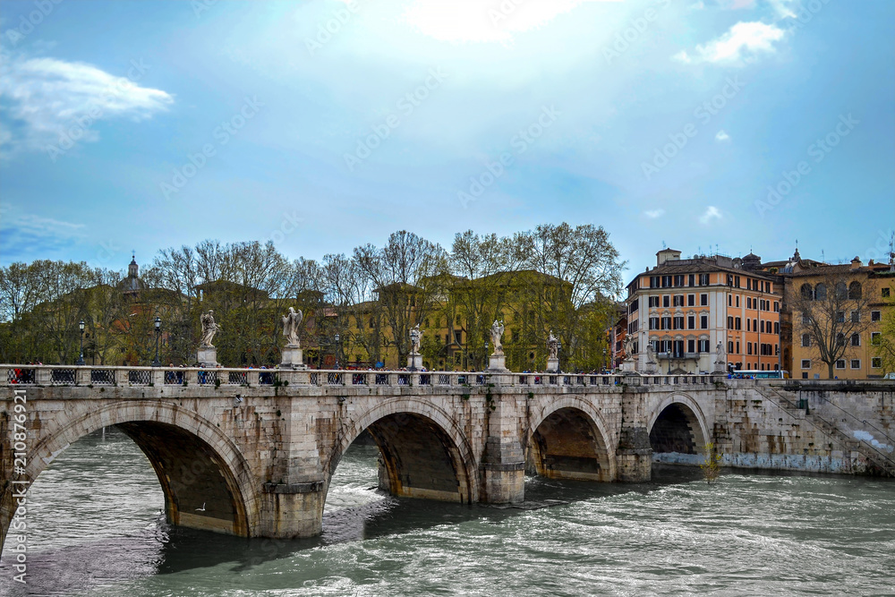 Tiber river with ancient city architecture of Rome and beautiful old stone bridge, Rome, Italy.