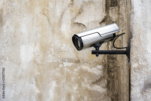 Surveillance camera on the wall background