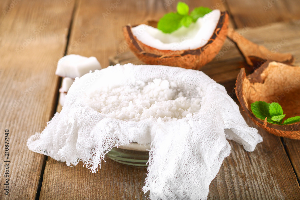 Squeezing milk from the chips of coconut in the gauze on an old wooden table. Squeezing milk from the chips of coconut in the gauze on an old wooden table.