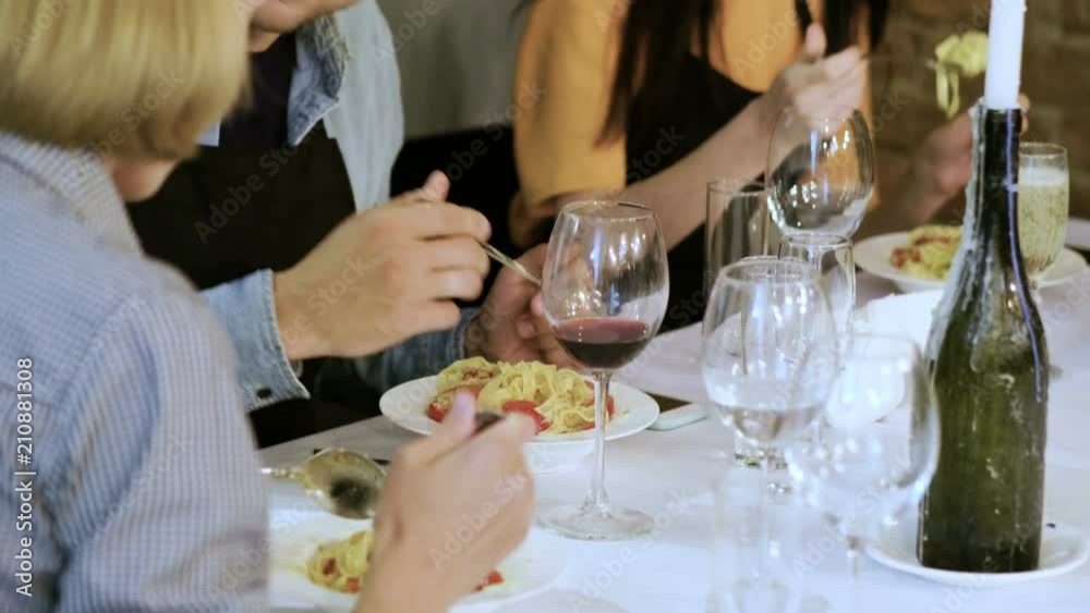 Two women, one man eating pasta with tomatoes, pesto sauce, parmesan cheese. 4K Two women, one man eating pasta with tomatoes, pesto sauce, parmesan cheese. 4K