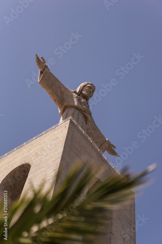 Statue Cristo Rei in lisbon - with palm tree.