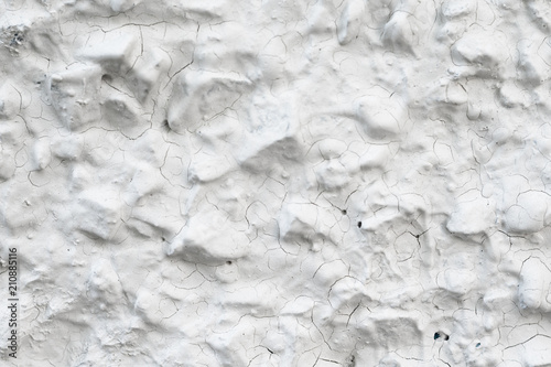 Rough Concrete Wall Decoration, Painted White. White Concrete Wall with Many Protruding Stones.