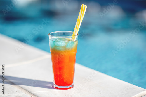 Close-up of summer cocktail on the beautiful blue water background during the sunlight