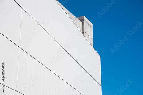 Monolithic structure of concrete. Concrete wall against a clear blue sky.