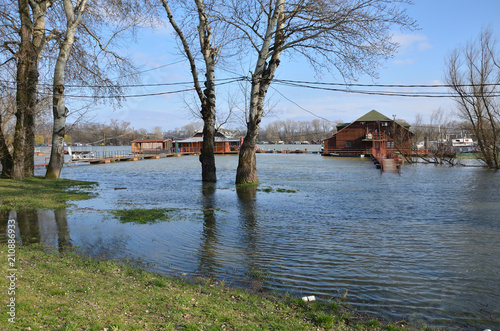 Fototapeta Naklejka Na Ścianę i Meble -  Flooded promenade along a river bank in a city area