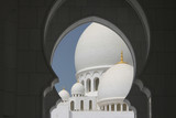 kopuły białego meczetu na tle niebieskiego nieba w Abu Dhabi, Zjednoczone Emiraty Arabskie 