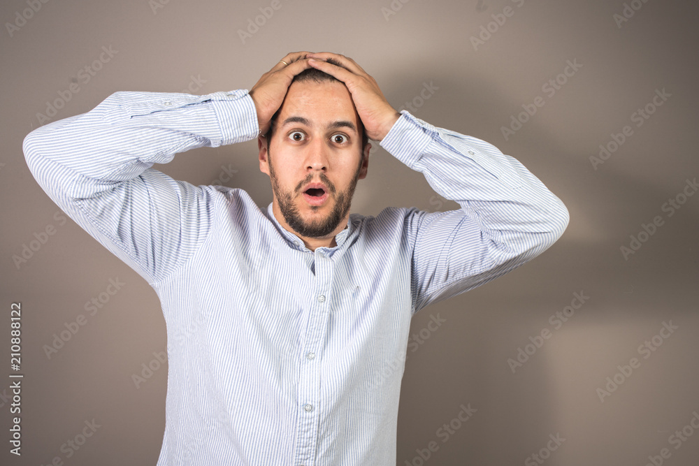 man with expression of amazement and hands on his head man with expression of amazement and hands on his head