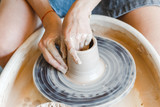 Top view of hands with clay making of a ceramic pot on the pottery wheel, hobby and leisure with pleasure concept
