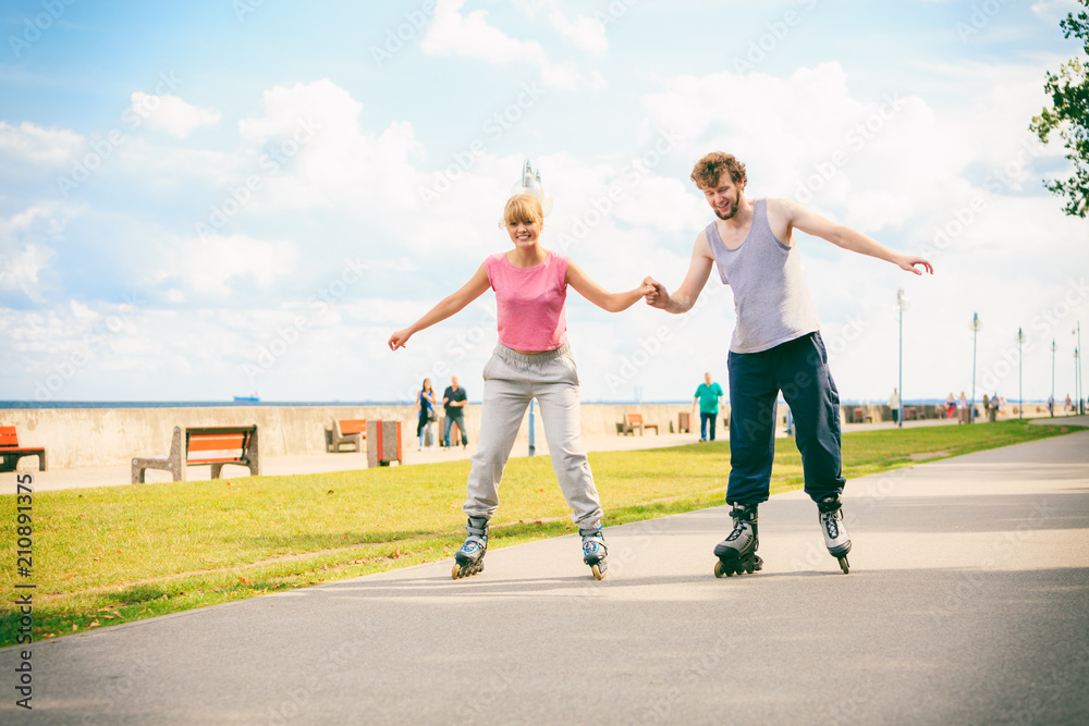 Fototapeta premium Active young people friends rollerskating outdoor.