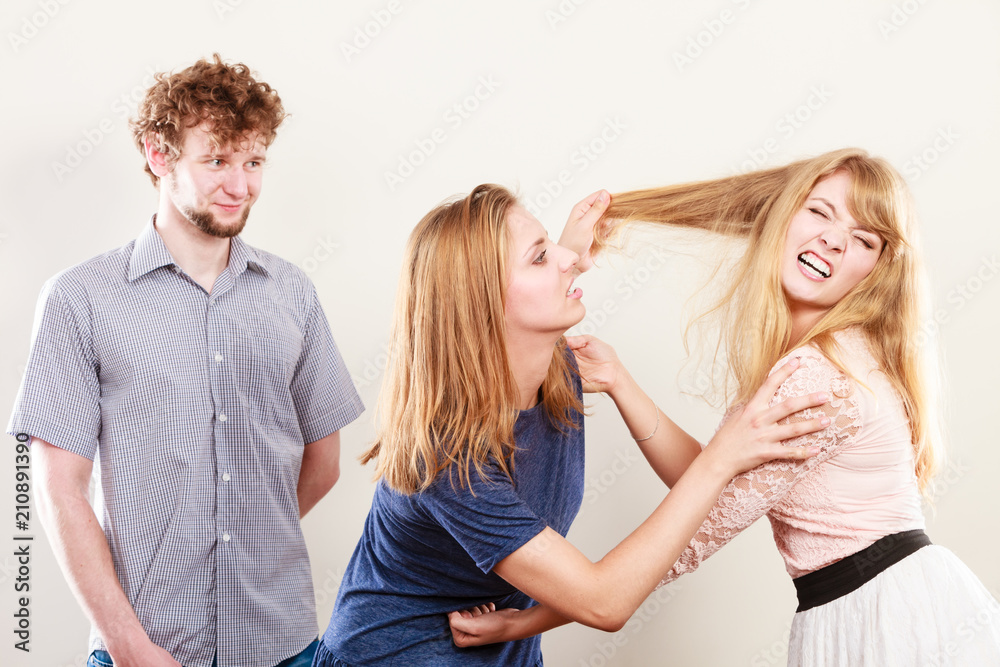 Aggressive mad women fighting over man. Aggressive mad women fighting over man.