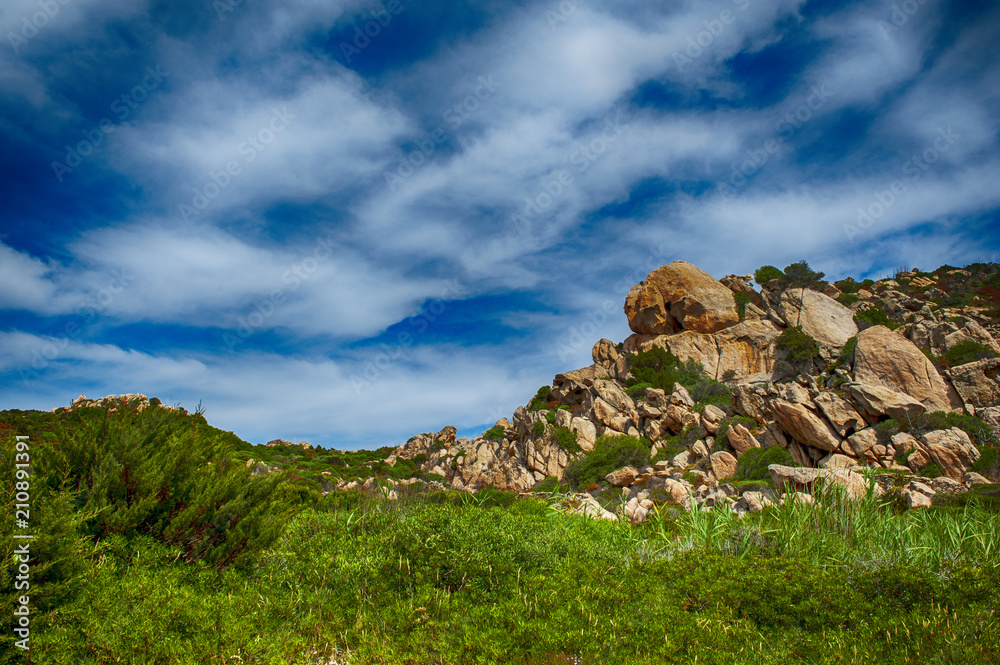 An amazing wild landscape of the hinterland of Sardinia where the green is mixed with pink granite that touches the sky