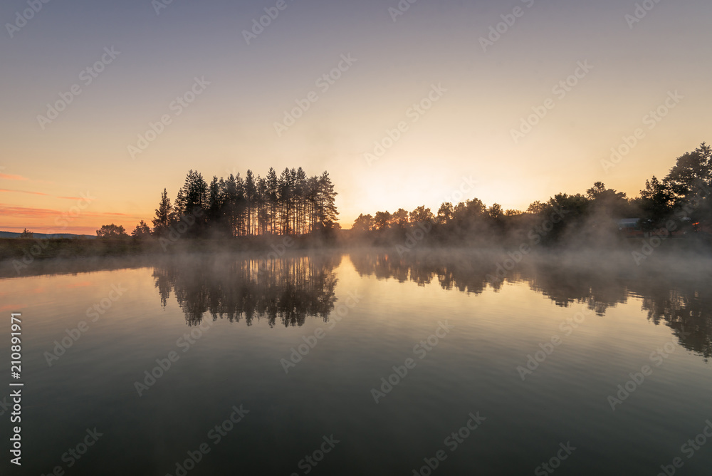 Morning fog on the forest lake,