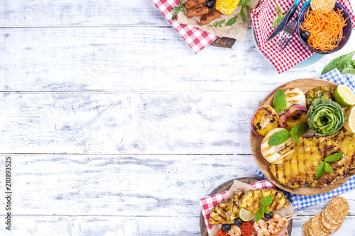 Vegetables, fruits and shrimp on the grill, for a summer lunch. Healthy food. Appetizers on a white background. Copy space. flat lay.