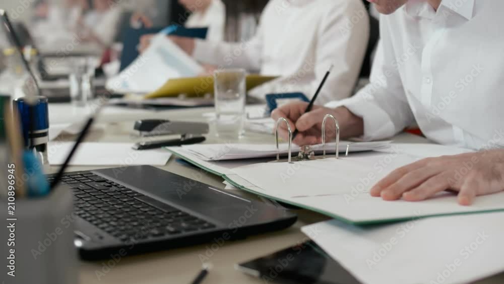 Close-up on overworked employee working in office with documents.