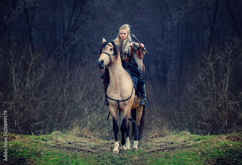 Warrior Woman on a horse in the woods. Reconstruction of a medieval scene