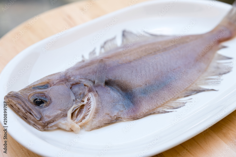 flounder fish on a white plate on wooden table