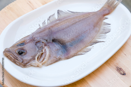 flounder fish on a white plate on wooden table