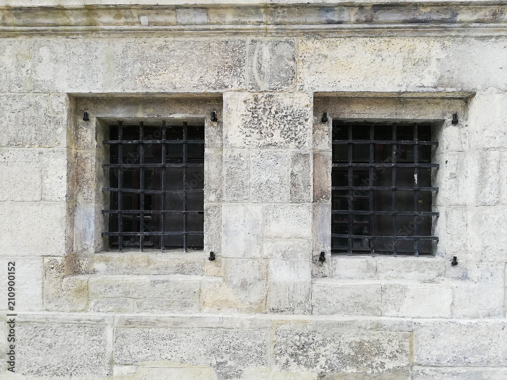 Fototapeta premium The windows in the concrete wall are covered with bars.