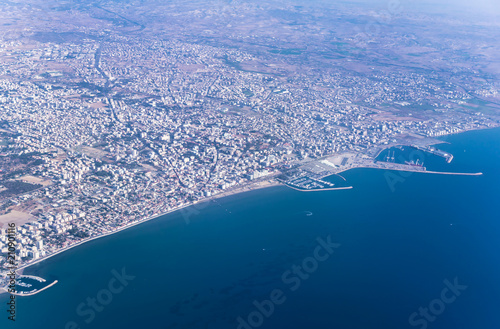 Airplane view over Cyprus, relief of the island and beautiful turquoise Mediterranean with boats and ships in the waters. Airplane wings in the early morning.