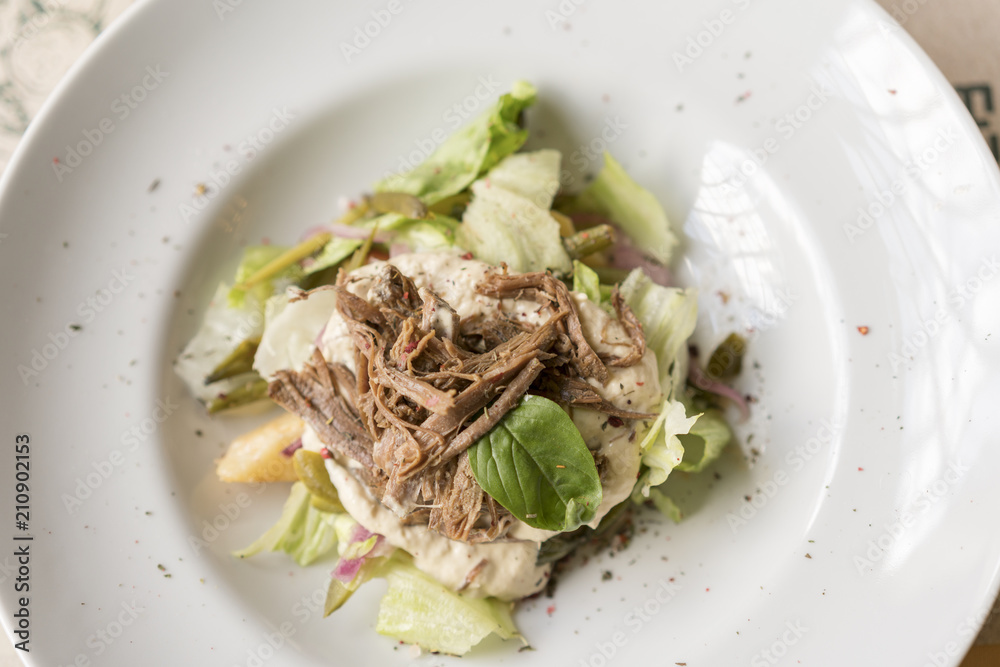 Warm salad with beef on a white plate. Warm salad with beef on a white plate.