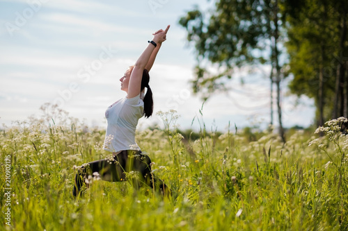 Young woman practicing yoga outdoor in park. Concept of healthy lifestyle and everyday practice