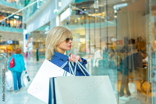 Fashion Shopping Girl Portrait. Beauty Woman with Shopping Bags in Shopping Mall. Shopper. Sales.