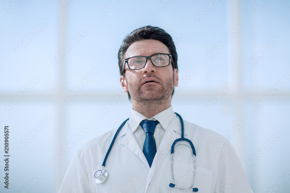 serious doctor on the background of a bright room serious doctor on the background of a bright room