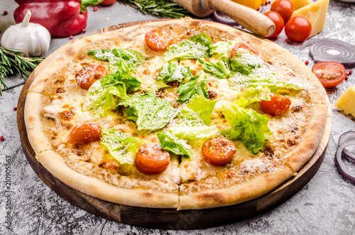 Homemade Vegan pizza with fresh vegetables and pesto, gray stone background, copy space, restaurant menu concept. Italian food style, close up.