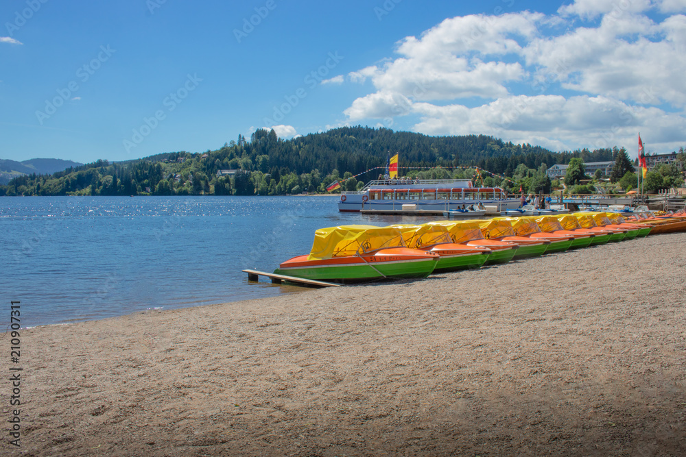 Fototapeta premium Seepanorama mit gelben Booten am Titisee im Schwarzwald/Germany