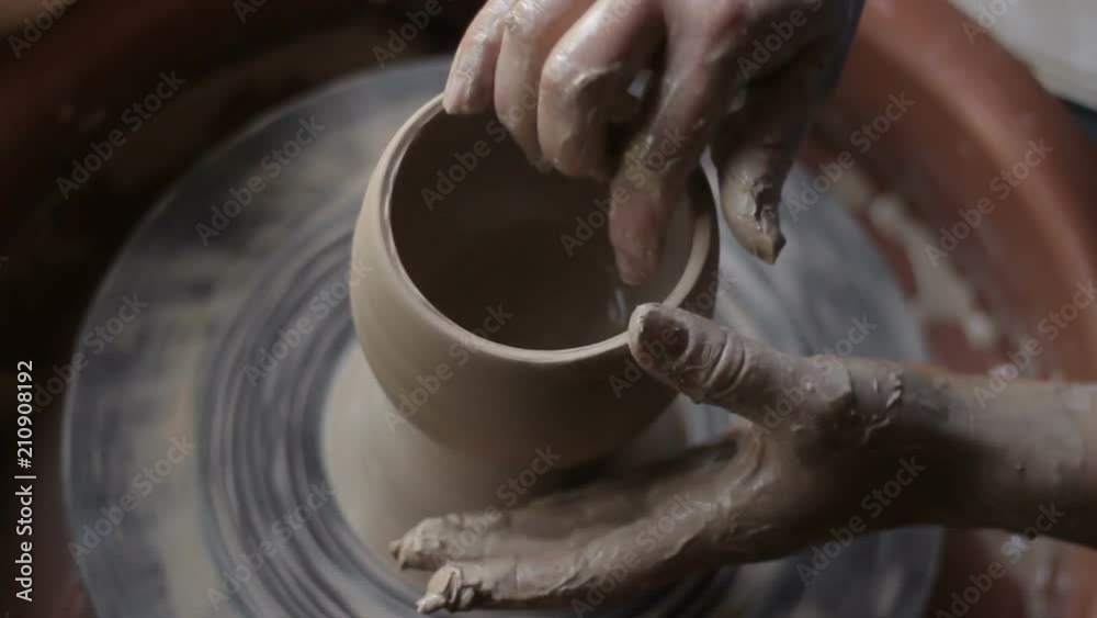 process of making pottery. Woman's hands and fingers forming clay into cup process of making pottery. Woman's hands and fingers forming clay into cup