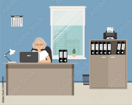 Elderly office worker in the workplace. The woman is sitting at the desk on a window background. There is also a cabinet with folders, a printer, a lamp, a calendar in the office room. Vector