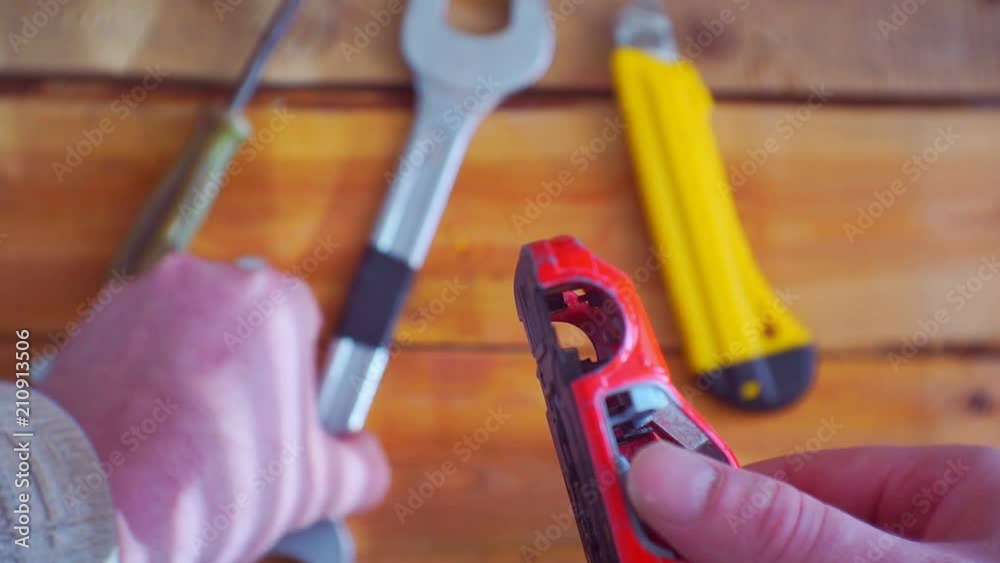 repair, maintenance and diagnostics of the car.metaphor.men's hands hold a small old broken toy car on a background of a wooden workbench with tools.Closeup.View from above