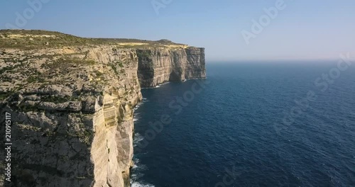 Scenic aerial view of dramatic high precipice with beautiful sea view. Drone top view shot of dangerous stony cliffs near the sea. Malta, Gozo
