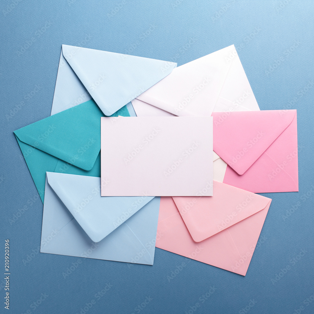 Group of colorful envelopes on grey table with empty card. Correspondence concept. Mockup. Group of colorful envelopes on grey table with empty card. Correspondence concept. Mockup.