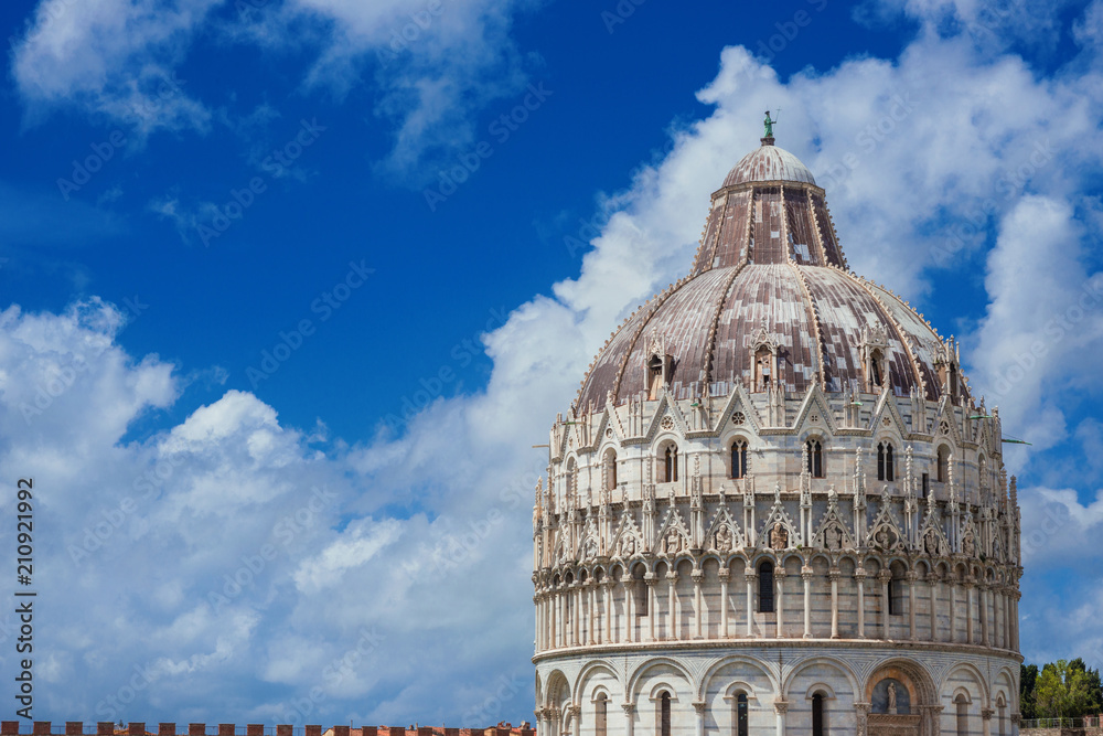 View of Pisa Baptistry medieval dome with clouds and city ancient walls (with copy space)