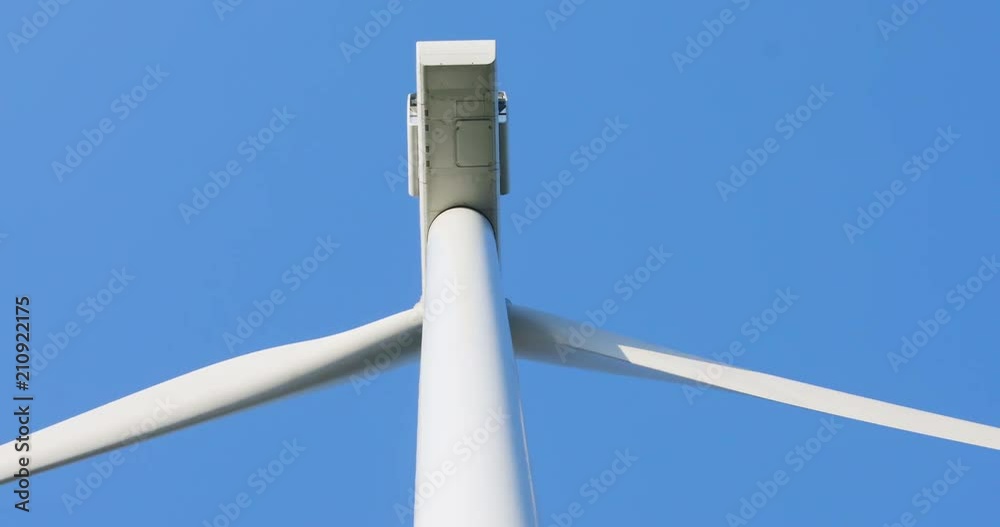 close-up view of windmill blades rotating propeller details of wind turbine in motion with clear blue sky on background summer day light new technology generation future ecosystem repair concept close-up view of windmill blades rotating propeller details of wind turbine in motion with clear blue sky on background summer day light new technology generation future ecosystem repair concept